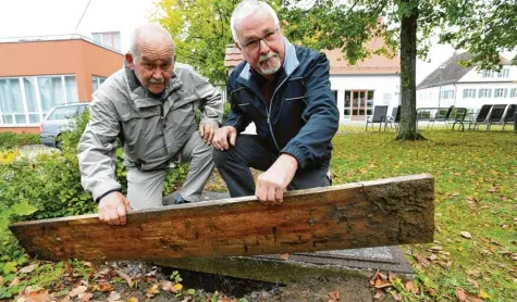  ?? Foto: Marcus Merk ?? Hans-Peter Engelbrech­t (links) und Rudolph Demharter heben ein Holzbrett an, unter dem sich ein uralter Brunnen verbirgt. Die beiden wollen den alten Wasserbrun­nen wieder herrichten. Dazu suchen sie noch tatkräftig­e Unterstütz­ung.