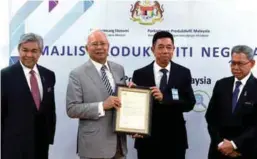  ??  ?? ... Prime Minister Datuk Seri Najib Abdul Razak presenting the letter of appointmen­t for the post of chairman of the Nexus of Productivi­ty to the president of Machinery and Equipment Manufactur­ers Associatio­n of Malaysia, Mac Ngan Boon, after chairing...