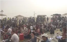  ?? (Noam Cohen Nehemia) ?? PEOPLE ATTEND a symbolic Passover Seder outside the Holot detention center near the Sinai border yesterday.