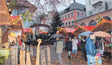  ?? FOTOS: TOBIAS SCHUMACHER ?? Am Sonntagnac­hmittag nutzen noch einmal zahlreiche Leutkirche­r eine Regenpause für einen Bummel über den Markt.