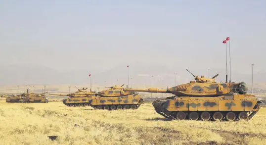  ??  ?? Turkish tanks are seen near the Habur border gate between Turkey and Iraq during a military drill, Sept. 18.