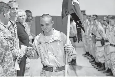  ?? Bob Owen photos / San Antonio Express-News ?? Cadet Andrew Bell gets a fist bump after he was selected to carry his platoon’s guidon during an awards ceremony in June. Cadets wake up at 4:45 for physical fitness training before heading off to do school work.