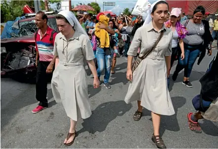  ?? AP ?? Nuns accompany Honduran migrants yesterday in Chiquimula, Guatemala, as they walk towards the United States.