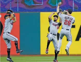  ?? RON SCHWANE/THE ASSOCIATED PRESS ?? The Twins’ Eddie Rosario, left, Byron Buxton and Max Kepler celebrate an 8-6 win over the Indians Tuesday in Cleveland. Minnesota’s magic number to clinch a playoff berth is down to one game.