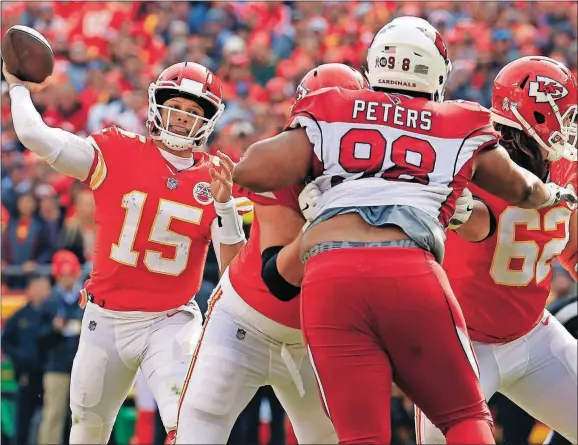  ??  ?? City Chiefs quarterbac­k Patrick Mahomes (15) throws a touchdown pass to wide receiver Tyreek Hill as offensive lineman Andrew Wylie (77) blocks Cardinals defensive tackle Corey Peters (98) during the first half Sunday in Kansas City, Mo. [CHARLIE RIEDEL/THE ASSOCIATED PRESS]