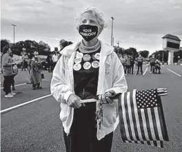  ?? BRYNN ANDERSON/AP ?? A supporter waits to hear Georgia Democratic candidates for U.S. Senate Jon Ossoff and RaphaelWar­nock speak during a rally Nov. 15 in Marietta, Georgia.