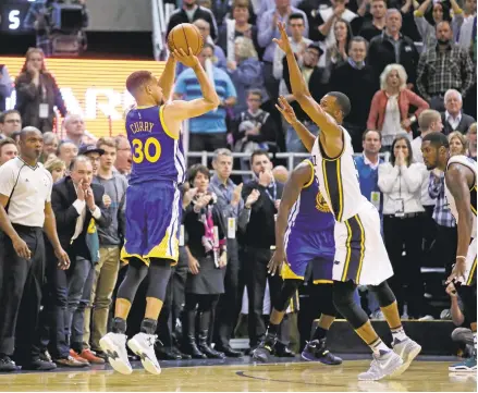  ?? RICK BOWMER/ASSOCIATED PRESS ?? Stephen Curry hits a 3-pointer over Utah’s Rodney Hood. Curry scored 26 points as the Warriors narrowly escaped with their 19th consecutiv­e win.