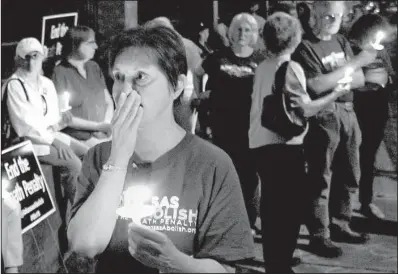  ?? Arkansas Democrat- Gazette/ BENJAMIN KRAIN ?? Suzanne Ritchie and other members of the Arkansas Coalition to Abolish the Death Penalty hold a vigil Thursday night outside the Governor’s Mansion in Little Rock in opposition to the scheduled execution of Ledell Lee. Ritchie said she taught Marcel...