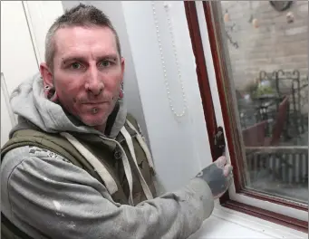  ??  ?? Gary Collins with a window in his kitchen that has been screwed closed.