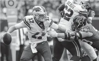  ?? Godofredo A. Vasquez / Staff photograph­er ?? Bills quarterbac­k Josh Allen, who would later leave the game with an elbow injury, feels the heat from Texans defensive end J.J. Watt in the third quarter.