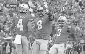  ?? JOSEPH MAIORANA/USA TODAY SPORTS ?? Ohio State wide receiver Julian Fleming (4) celebrates a touchdown catch with tight end Cade Stover (8) and running back Miyan Williams (3) during the second quarter against Rutgers.