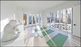  ??  ?? Designer Dana Lynch selected an all-white color palette to bring a sense of tranquilit­y to the yoga room of a Serenbe home that looks onto a custom labyrinth and pool.