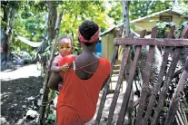  ?? DIEU NALIO CHERY/THE ASSOCIATED PRESS ?? Janila Jean, 18, carries her daughter as she walks to her friend’s house before an Aug. 15 interview in Jacmel, Haiti. Jean said she was a 16-year-old virgin when a U.N. peacekeepe­r from Brazil lured her to the U.N. compound two years earlier with a...