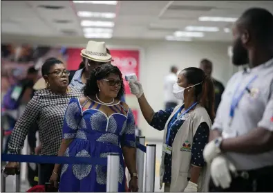  ?? (AP/Dieu Nalio Chery) ?? A Public Health Ministry nurse measures the temperatur­e of a passenger arriving from France at the Toussaint Louverture Internatio­nal Airport in Port-au-Prince, Haiti, earlier this month.