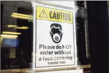  ?? Ned Gerard / Hearst Connecticu­t Media ?? A sign requiring masks or face covering hangs on the front door of the Morton Government Center in Bridgeport this summer.