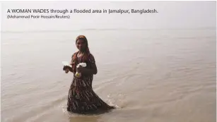  ?? (Mohammad Ponir Hossain/Reuters) ?? A WOMAN WADES through a flooded area in Jamalpur, Bangladesh.