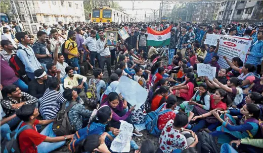  ??  ?? All riled up People sitting on railway tracks as they block train services during a protest demanding recruitmen­t into the railway services in Mumbai, India. — Reuters