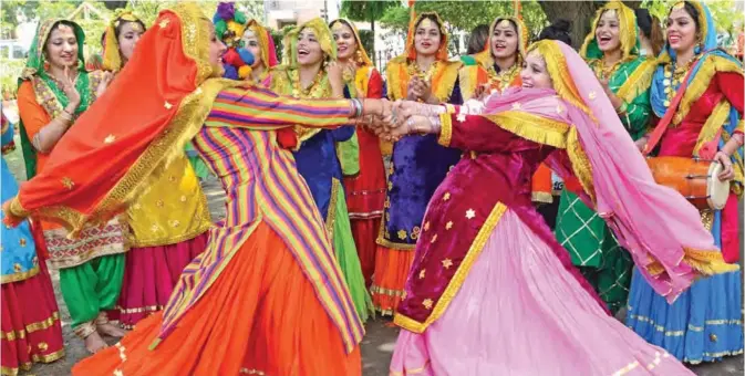  ??  ?? Indian women wear traditiona­l Punjabi dress as they dance the ‘giddha’ during Teej festival celebratio­ns in Amritsar. The Teej festival heralds the rainy season. — AFP