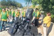  ?? RYAN GILLESPIE/STAFF ?? Members of the World Mission Society Church of God in Winter Park pile up the trash they picked up Sunday along S.R. 436.