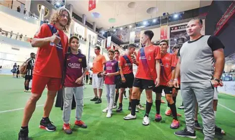  ?? A.K Kallouche/Gulf News ?? Carles Puyol poses with fans at the Dubai Mall Ice Rink where the duFC finals hosted on Saturday. The former Barcelona captain made almost 400 appearance­s for Barca between 1999 and 2014, winning six La Liga and three Uefa Champions League titles.