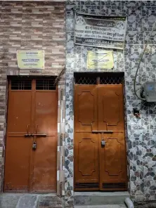  ?? (Stuti Mishra/The Independen­t) ?? Banners of NGOs pasted above the doors of the houses which were rebuilt with their donations after they were burnt down