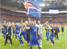  ?? Martin Meissner / Associated Press ?? Goal scorer Arnor Ingvi Traustason (21) and goalkeeper Hannes Halldorsso­n (1) lead the celebratio­n of Iceland’s historic moment.