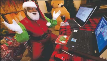  ?? (AP/LM Otero) ?? Larry Jefferson portrays Santa Claus and visits via computer with Raquel Anaya and her cousins Lexi and Luna Reyes from his home in Duncanvill­e, Texas.