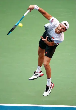  ?? AP Photo/Andres Kudacki ?? ■ Joao Sousa of Portugal serves to Novak Djokovic of Serbia during the fourth round of the U.S. Open on Monday in New York. Djokovic won in straight sets.