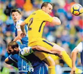  ?? AFP ?? El defensor charrúa del Atlético de Madrid, Diego Godín, le gana el balón en las alturas al tico Celso Borges.