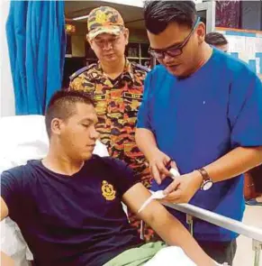  ?? [ FOTO IHSAN BOMBA ] ?? Waslie mendapatka­n rawatan selepas cedera ketika memadamkan kebakaran di Kampung Bau, semalam.