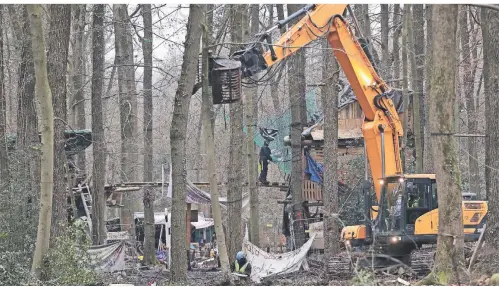  ?? FOTOS: DAVID YOUNG/DPA ?? Mit schwerem Gerät wird das Gelände mit den Baumhäuser­n derzeit von der Polizei geräumt.