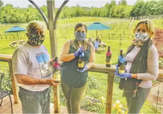  ?? BY JOHN MCCASLIN ?? Gadino Cellars in Washington is open for outside tastings and bottle sales under Phase 1 of Virginia Gov. Ralph Northam’s reopening plan. “All our employees wear masks . . . and the gloves are changed out between servings,” guarantees owner Bill Gadino, seen here with the winery’s Kaitlyn Haney (center) and Kit Johnston.