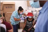  ?? LYNNE SLADKY — THE ASSOCIATED PRESS FILE ?? Registered nurse Ashleigh Velasco, left, administer­s the Johnson & Johnson COVID-19 vaccine to Rosemene Lordeus, right, at a clinic held by Healthcare Network in Immokalee, Fla.