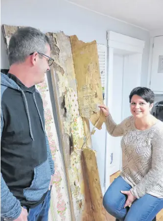  ??  ?? Owner Sharilee Anderson and friend, James Osborne, turning back seasoned wallpaper layers to uncover old newsprint.