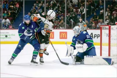  ?? The Canadian Press ?? Vancouver Canucks goaltender Thatcher Demko makes a save against Anaheim Ducks’ Mason McTavish with Canucks’ J.T. Miller defending during the third period of the game in Vancouver on Wednesday.