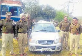  ??  ?? Policemen with the Maruti Alto K10 car that was found abandoned hours after it tried to run over a police party, near the J&KPunjab border in Sujanpur on Saturday. n HT PHOTO