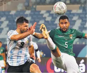  ??  ?? Empuje. Adrián Jusino, de Bolivia, disputa un balón con Sergio Agüero.