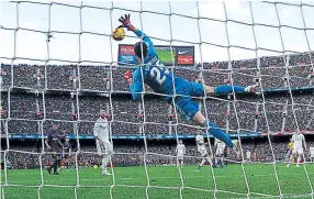  ??  ?? impresiona­nte. Courtois, portero del Real Madrid, vuela para evitar el gol de Arthur, del Barcelona.