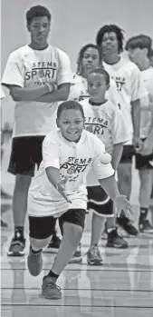  ?? PHOTOS BY ANGELA PETERSON / MILWAUKEE JOURNAL SENTINEL ?? Isaac Servantez, 10, participat­es in an agility drill while warming up with other campers at the “STEM and Sport Team Up” camp at Marquette University. In addition to a variety of drills, participan­ts were exposed to the science behind the sports they love to play.