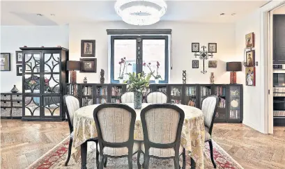  ?? THE PRINT MARKET PHOTOS ?? The dining room features a herringbon­e hardwood floor, a crystal light fixture, built-in cabinetry and a pair of skylights.