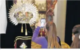  ??  ?? Una joven fotografía la corona de la Virgen de la Presentaci­ón.