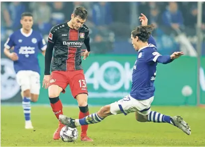  ?? FOTO: REUTERS ?? Leverkusen­s Torschütze Lucas Alario (l.) wird von Schalkes Benjamin Stambouli hart attackiert.