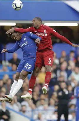  ?? — AP ?? Willian ( left) of Chelsea and Liverpool’s Georginio Wijnaldum vie for an aerial ball during their English Premier League match at Stamford Bridge stadium in London on Saturday. The match ended in a 1- 1 draw.