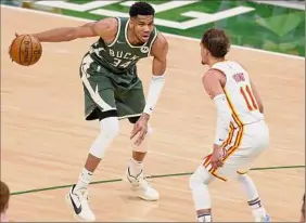  ?? Patrick Mcdermott / Getty Images ?? Giannis Antetokoun­mpo, left, of the Bucks is listed as doubtful to play in Game 6 against Trae Young, right, and the Hawks. Young is questionab­le.