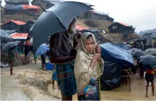  ?? AP ?? A Rohingya woman stands drenched in the rain at Balukhali refugee camp in Cox’s Bazar, Bangladesh, on Wednesday. —