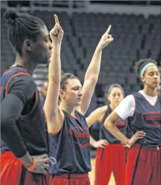  ?? DAVID JABLONSKI / STAFF ?? Dayton senior Andrea Hoover (center) leads her Flyers teammates in a moment of meditation before their practice Friday at the Times Union Center in Albany, N.Y.