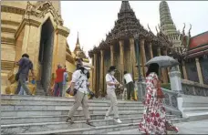  ?? ANUSAK LAOWILAS / NURPHOTO VIA GETTY IMAGES ?? Tourists visit the Temple of the Emerald Buddha in Bangkok on May 1.