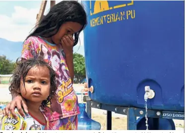  ?? AFP ?? Dazed and alone: Children at a temporary camp in Palu getting access to drinking water. A huge number of them have been left orphaned or separated from their families in the chaos as buildings collapsed across the city and people were swept away by huge waves. —