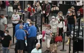  ?? DAVID ZALUBOWSKI — THE ASSOCIATED PRESS ?? Travelers wear face coverings in the line for the south north security checkpoint in the main terminal of Denver Internatio­nal Airport in Denver.