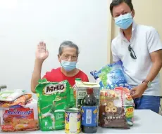  ??  ?? Yong (standing) handing over the food basket to Soon, who expressed his gratitude to Karunanith­y and his team.